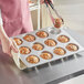 A person holding a muffin in a Baker's Mark jumbo muffin pan.
