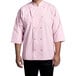 A man wearing a pink Uncommon Chef 3/4 length sleeve chef coat with side vents.