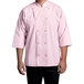 A man wearing a pink Uncommon Chef 3/4 sleeve chef coat with side vents.