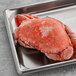 A frozen Chesapeake Crab Connection Dungeness crab on a metal tray.