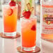A close-up of two glasses of pink Monin Strawberry Ginger Lemonade.
