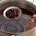 A person using a colander to strain brown Bossen Large Tapioca Pearls.