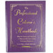 A purple copy of The Professional Caterer's Handbook with gold text on a kitchen counter.
