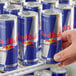 A person holding a close-up of a blue and white Red Bull can.