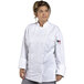 A woman wearing a Uncommon Chef white long sleeve chef coat with mesh back.