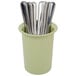 A sage green Cal-Mil flatware cylinder holding utensils.