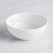 An Acopa Capri coconut white stoneware bistro bowl on a white surface.