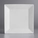 An Acopa bright white square porcelain plate on a gray surface.