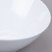 A white GET San Michele slanted melamine bowl on a gray surface.