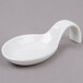 A white spoon with a curved handle.