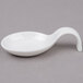 An Arcoroc white china spoon with a curved handle.