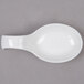 An Arcoroc white china spoon with a white spoon shaped bowl on a gray surface