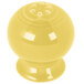 A close-up of a yellow Fiesta pepper shaker with holes.