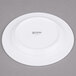 An Arcoroc white porcelain plate with black text reading "Arcoroc"