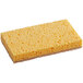 A yellow sponge with a brown surface.