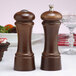 Two brown wooden salt and pepper shakers on a table.