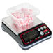 A Rubbermaid Pelouze digital portion scale with a container of candy on top.