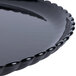 A close up of a black GET Mediterranean polycarbonate plate with a scalloped edge.