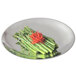 A Vollrath stainless steel round platter with asparagus and carrots on it.