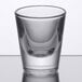 A Libbey shot glass on a table with a reflection.