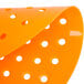 An orange plastic Lavex urinal screen with holes.