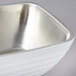 A pearl white Vollrath double wall metal bowl with a silver rim.