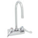 A chrome Equip by T&S wall mounted faucet with wrist handles and a gooseneck spout.