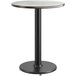 A round table with a white surface and black edge on a black pole with a round base.