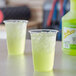 Two plastic cups with ice and green Sqwincher Lemon Lime beverage sitting on a counter.
