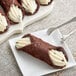 A Brooklyn Cannoli large chocolate cannoli shell filled with white cream.