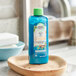 A blue bottle of Herbal Essences Bio:Renew Argan Oil conditioner on a wooden dish.