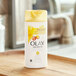 A yellow Olay Ultra Moisture body wash bottle on a wooden tray.