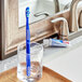 An Oral-B Healthy & Clean toothbrush in a glass on a counter.