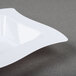 A white Fineline square plastic bowl with a curved edge.