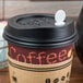 A coffee cup with a Royal Paper Stix To Go beverage plug and stirrer in the lid.