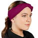 A woman wearing a berry chef neckerchief on her head.
