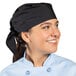 A woman wearing a black Uncommon Chef bandana in a professional kitchen.
