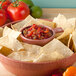 A bowl of tortilla chips with salsa and tomatoes in a HS Inc. paprika salsa bowl.