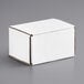 A Lavex white tuck top corrugated mailer box on a gray surface.