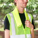 A man wearing sunglasses and a safety vest using an Ergodyne Hi-Vis Lime Cooling Towel.