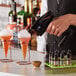 A bartender using a Flavour Blaster to add bubbles to a cocktail.