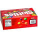 A red SKITTLES candy pouch with colorful candies.