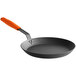 A black Lodge carbon steel frying pan with an orange silicone helper handle.