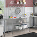 A kitchen with a Regency chrome wire baker's rack shelf and a white wall with a black handle.