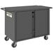 A grey steel Durham Mobile Job Site Cabinet with wheels and two doors.