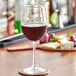 An Acopa Select Flora wine glass filled with red wine on a table