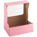 A pink Baker's Mark bakery box with a white window.