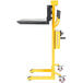 A yellow steel Vestil portable hand winch lifter with black forks and platform.