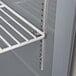 A white metal shelf with holes inside a Beverage-Air worktop freezer.