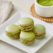A plate of green macarons with a bowl of Jade Leaf Organic Culinary Matcha Powder.